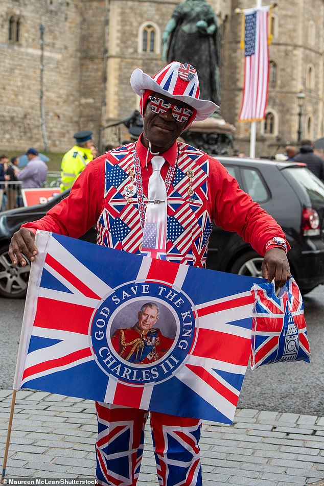A royal supporter poses for photos in front of Windsor Castle this morning