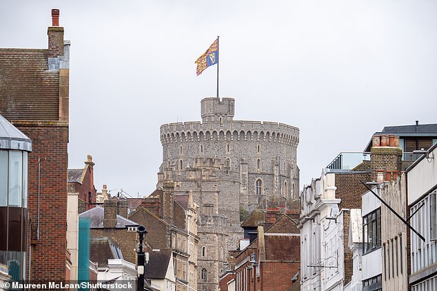 A gigantic royal standard is pictured flying from the Royal Tower of Windsor Castle today