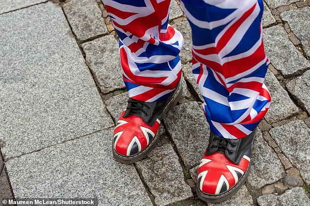 A royal supporter poses for photos in front of Windsor Castle this morning