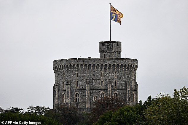 A gigantic royal standard is pictured flying from the Royal Tower of Windsor Castle today