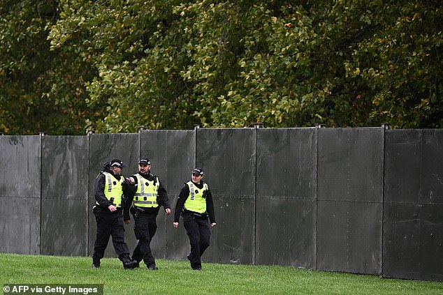 Police officers stand guard by a temporary fence blocking off the Long Walk at Windsor today
