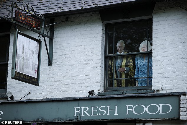 Cardboard cut-outs of Charles and Camilla in a window at the Windsor Castle pub today