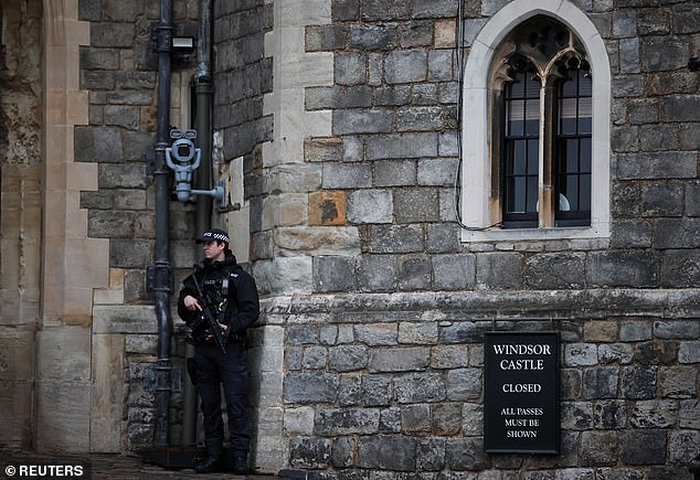An armed police officer stands outside an entrance to Windsor Castle this morning