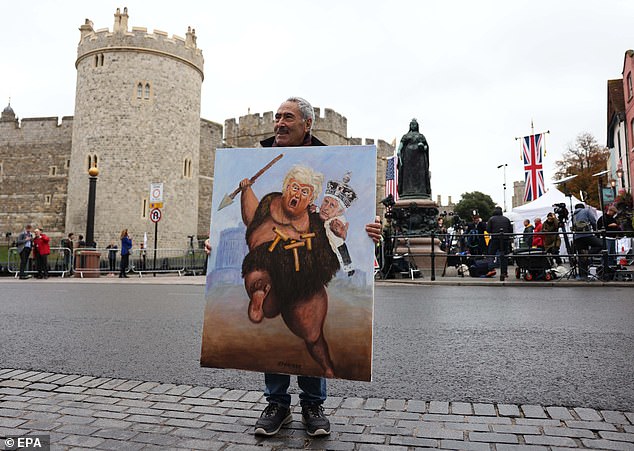 Artist Kaya Mar holds a painting depicting Donald Trump and King Charles in Windsor today