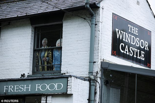 Cardboard cut-outs of Charles and Camilla in a window at the Windsor Castle pub today