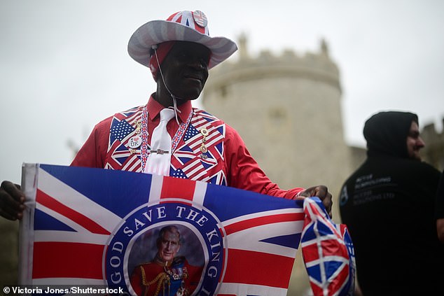 A royal supporter poses for photos in front of Windsor Castle this morning