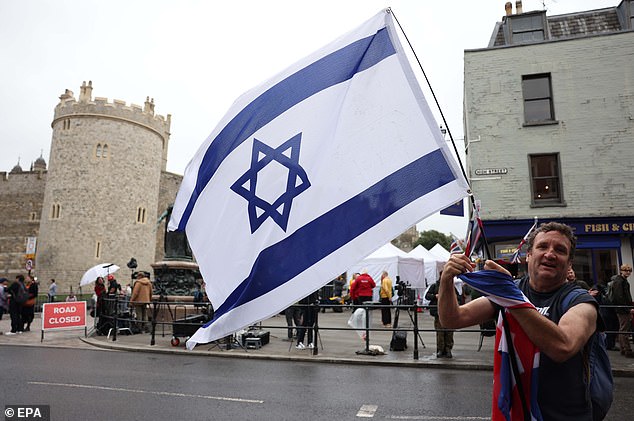 A person flies the flag of Israel outside Windsor Castle today as the state visit begins