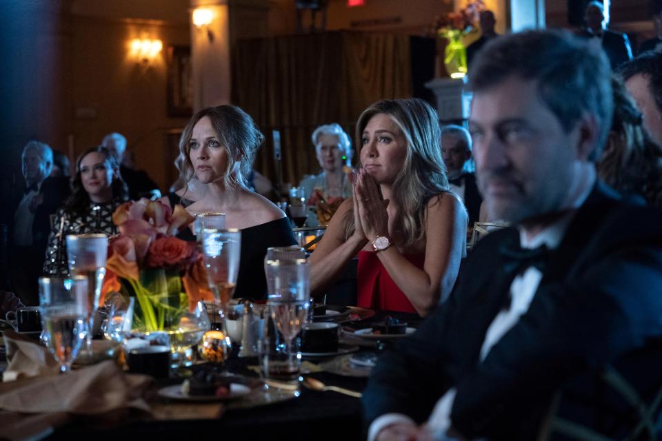 Reese Witherspoon and Jennifer Aniston from The Morning Show sit at a formal event.
