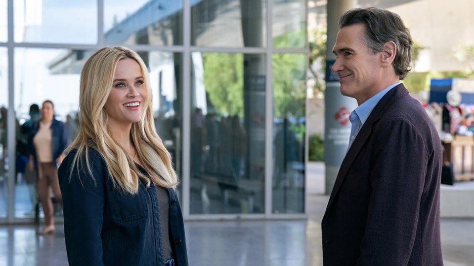Reese Witherspoon and Billy Crudup smile at each other in a scene from The Morning Show.