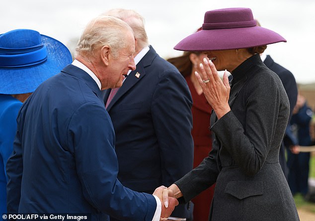 She wore her blonde tresses in a slick bun that was largely hidden by a wide-brimmed hat in a slightly brighter purple hue