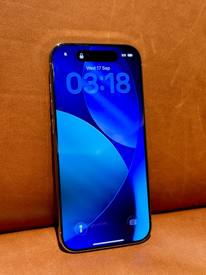 iPhone showing its lock screen with the date, time, and camera and flashlight icons at the bottom.