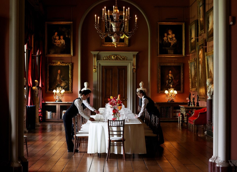 Catering staff setting a long dining table in the renovated Long Gallery at Castle Howard.