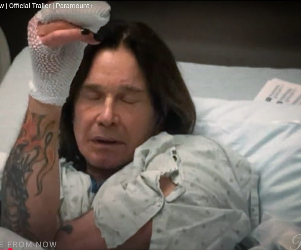 Ozzy Osbourne in a hospital bed with his arm wrapped.
