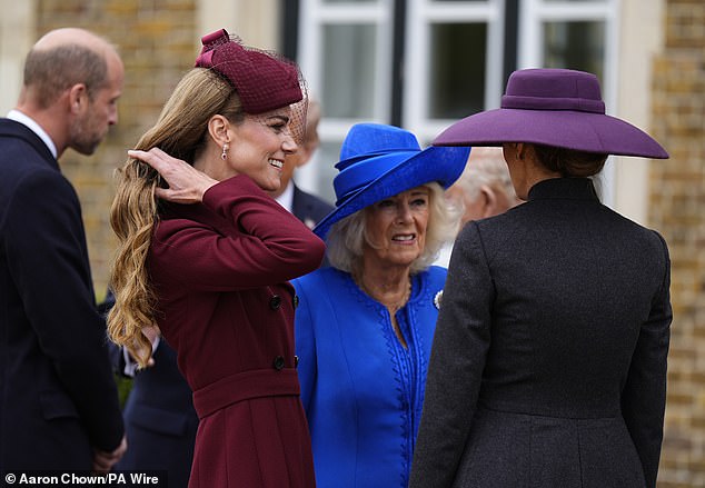 Kate adjusted her long 'bronde' locks as she chatted with Melania and the Queen