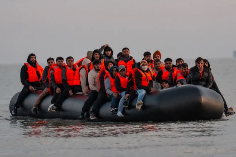 Migrants in a small boat at sea.