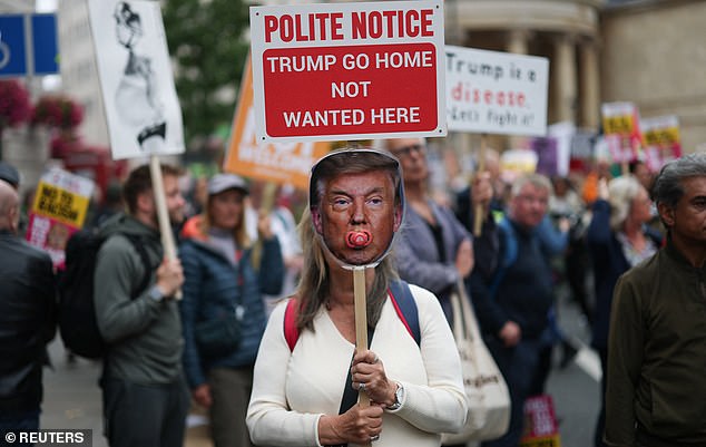 A demonstrator holds a sign as she takes part in a 'Trump Not Welcome' protest during the state visit of U.S. President Donald Trump and first lady Melania Trump, in London, Britain, September 17, 2025. REUTERS/Hannah McKay
