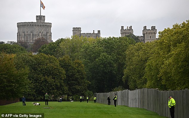 Police officers stand guard by a temporary fence, blocking off the Long Walk in the grounds of Windsor Castle, in Windsor, on September 17, 2025, during US President Donald Trump's second State Visit to the UK. US President Donald Trump arrived in Britain on Tuesday for an unprecedented second state visit, with the UK government rolling out a royal red carpet welcome to win over the mercurial leader. (Photo by Paul ELLIS / AFP) (Photo by PAUL ELLIS/AFP via Getty Images)
