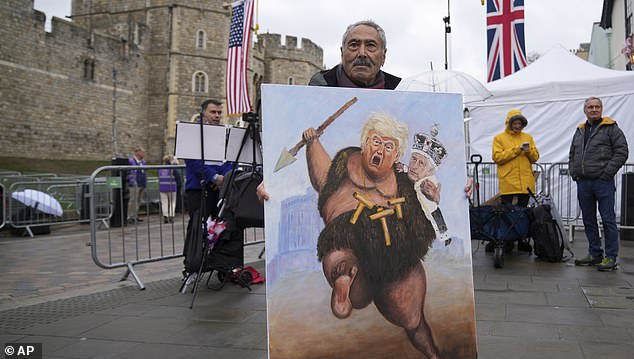 Artist Kaya Mar poses with his latest painting besides Windsor Castle ahead of the arrival of President Donald Trump in Windsor, England, Wednesday, Sept. 17, 2025.(AP Photo/Alastair Grant)