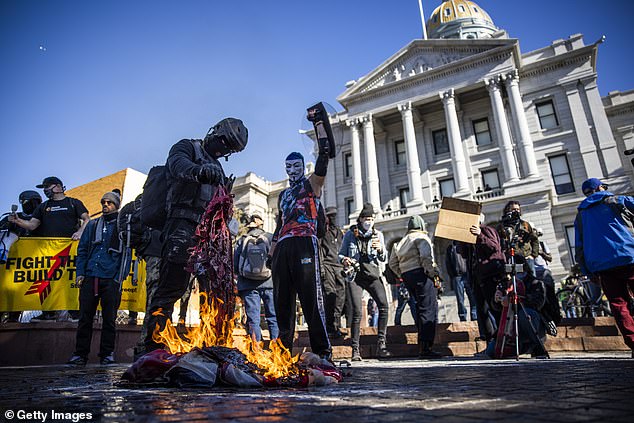 Trump described the Antifa movement as 'sick and dangerous' (pictured: 2021 protestors setting a flag on fire)