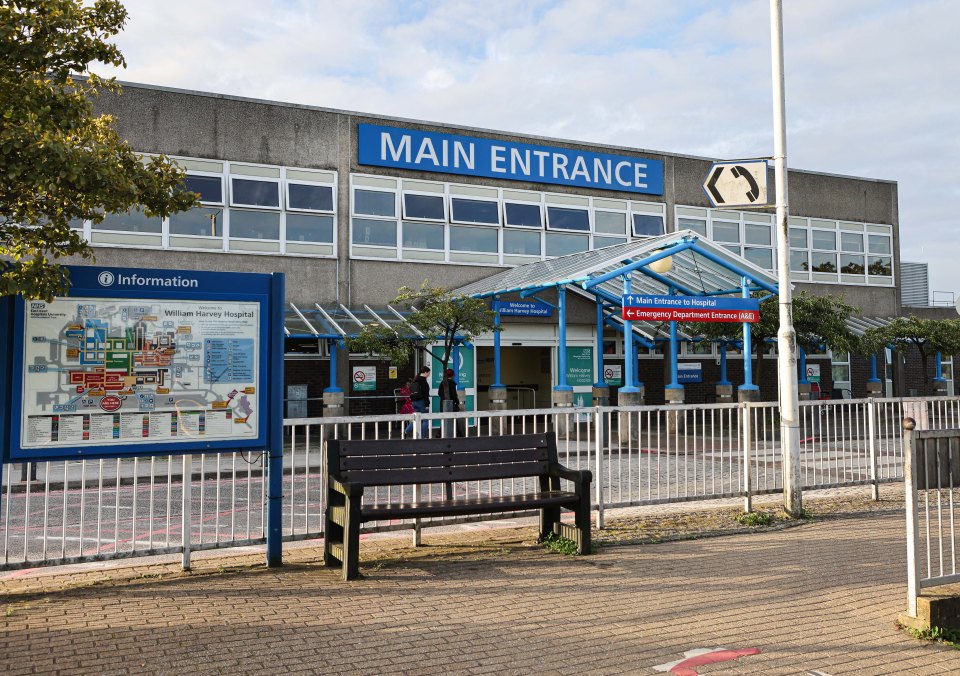 Exterior view of William Harvey Hospital in Ashford, Kent, with a "MAIN ENTRANCE" sign.