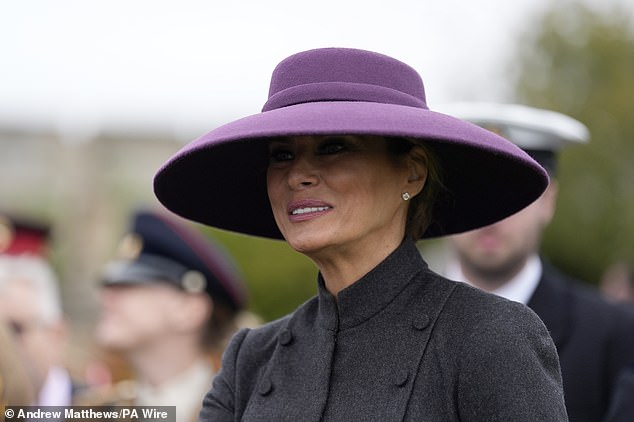 First Lady Melania Trump is seen smiling beneath a wide-brimmed wool hat