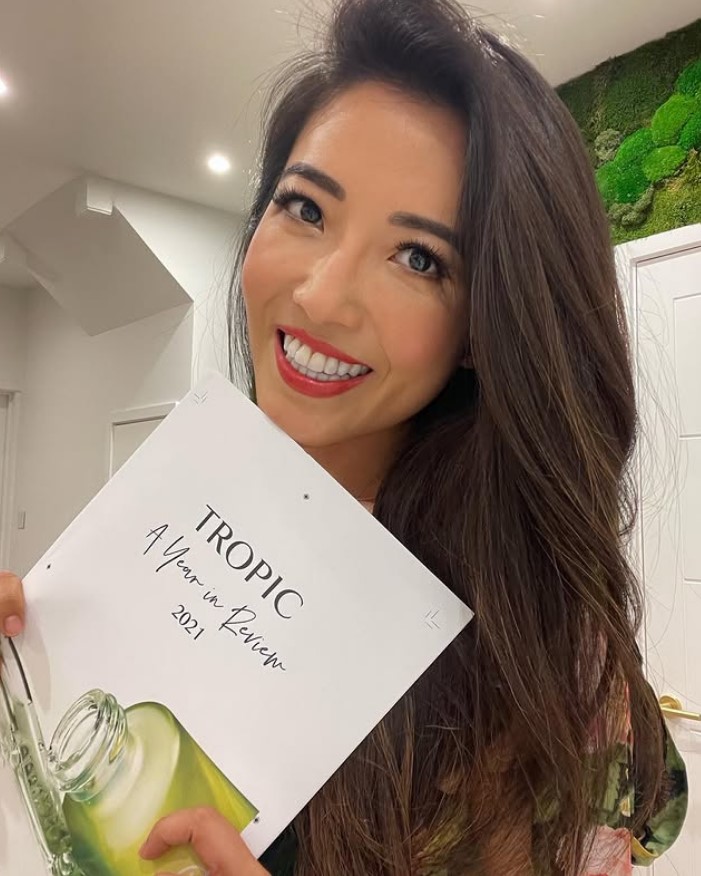 Susie Ma holding a "Tropic: A Year in Review 2021" booklet.
