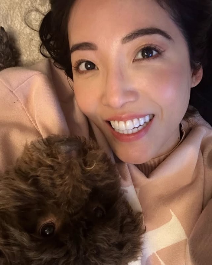 Susie Ma, from "The Apprentice", smiles with a dog.