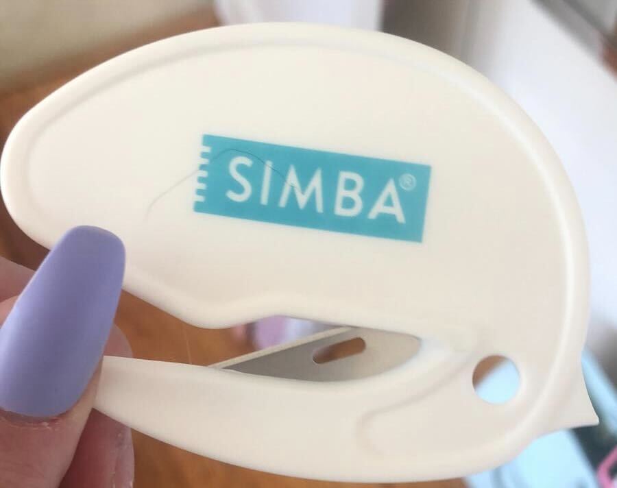 a person holding a white item with a simba logo on it