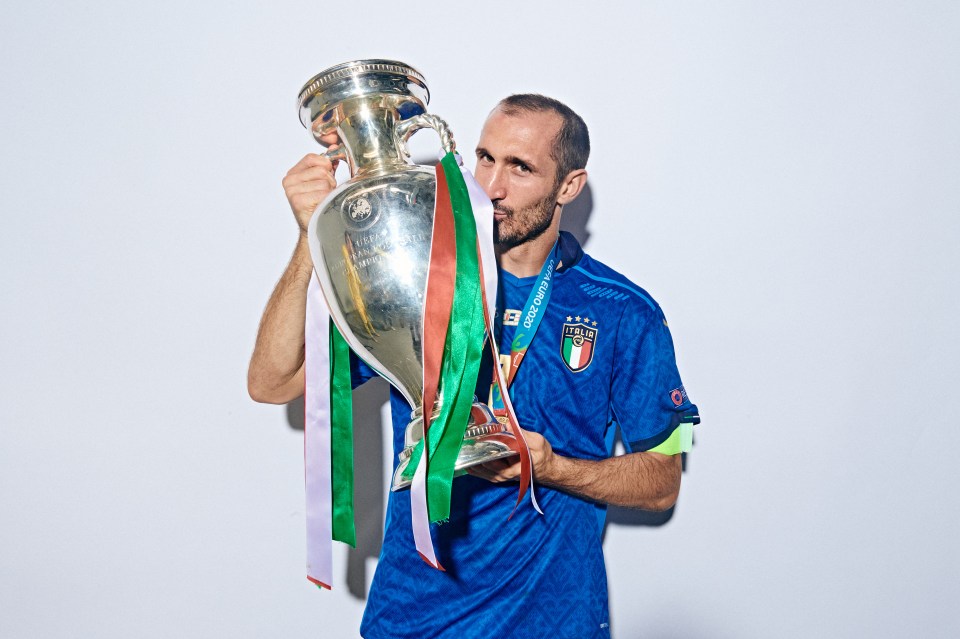 Giorgio Chiellini holding and kissing the Henri Delaunay Trophy.
