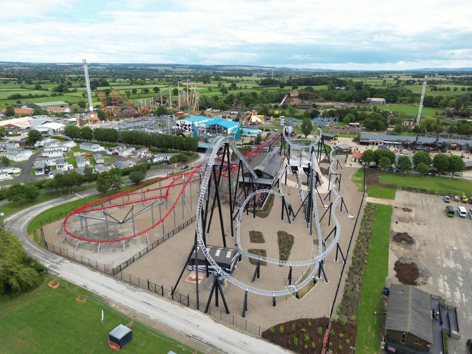 Aerial view of Flamingo Land Resort in Yorkshire, UK, showing the Sik rollercoaster and other rides.