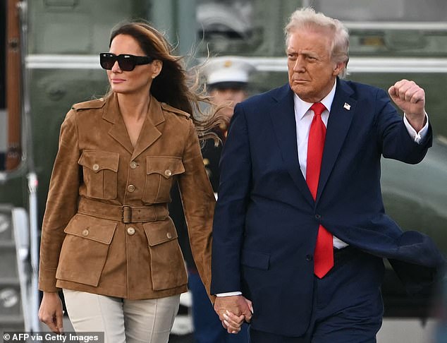 Trump raised a clenched fist in the air as he walked hand-in-hand with his wife Melania across the tarmac at Stansted Airport