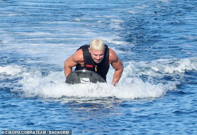 Efron, meanwhile, flaunted his sculpted abs as he dove into the sea and zipped around on a water scooter, drawing plenty of attention during the sun-drenched holiday