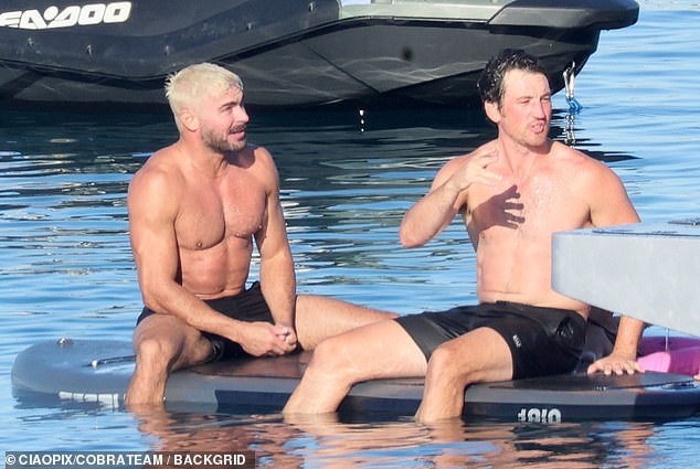 Teller and Efron seen sitting next to each other
