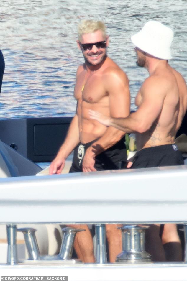 Shirtless Zac smiled as he soaked up the sun