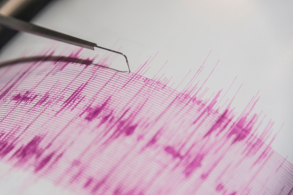 Seismograph showing earthquake activity on pink graph paper.