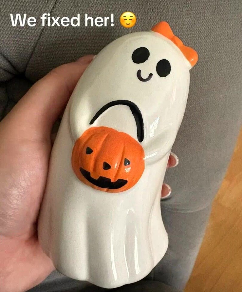 A ghost-shaped Halloween ornament holding a pumpkin with its sad mouth painted to look like a happy one.