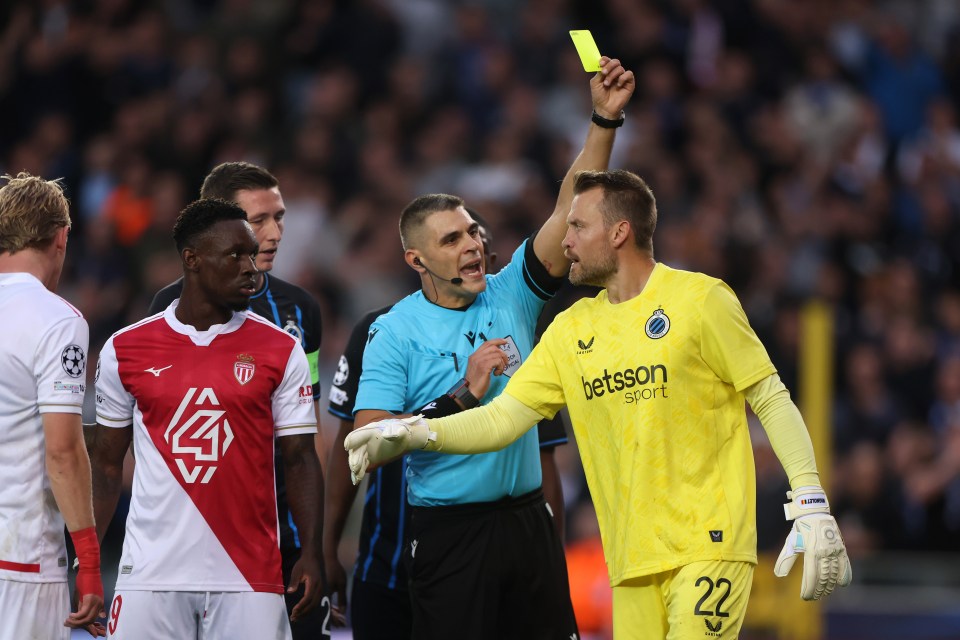 Referee Simone Sozza shows a yellow card to Simon Mignolet.