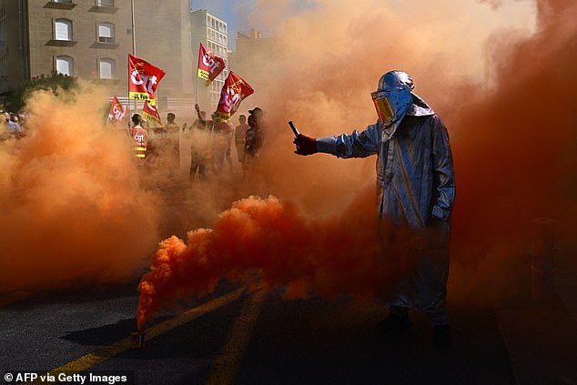 A protester lights flares in Marseille, southeastern France, on September 18, 2025, during a day of nationwide strikes and protests called by unions over France's national budget