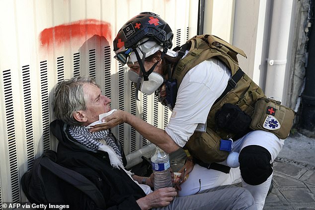 A street medic takes care of a man in Paris on September 18, 2025, during a day of nationwide strikes and protests called by unions over France's national budget