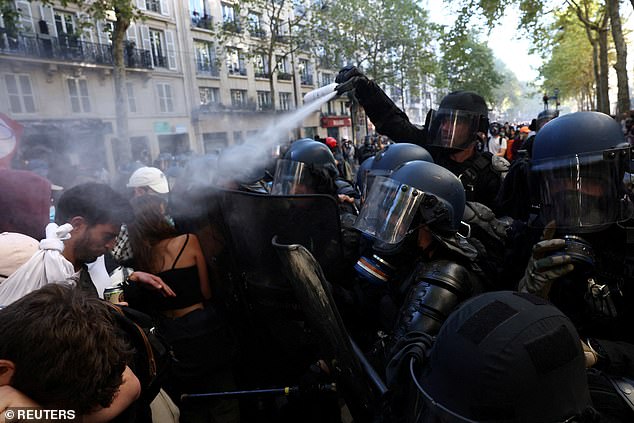 French riot police use tear gas on protesters during clashes at a demonstration in Paris as part of a day of nationwide strikes
