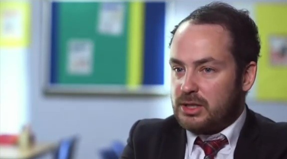Man in a suit and tie talking.