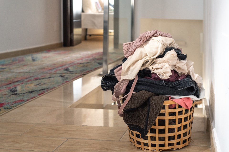 Basket with laundry on a tiled floor.