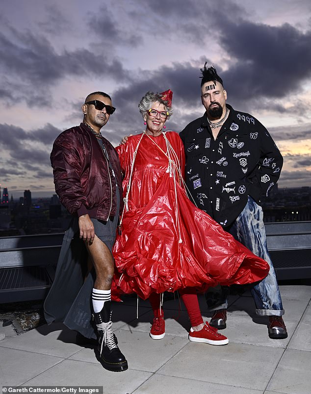 The TV star complimented her look with a small red hat and accessorised with fuchsia earrings (pictured with designers Vin and Omi)