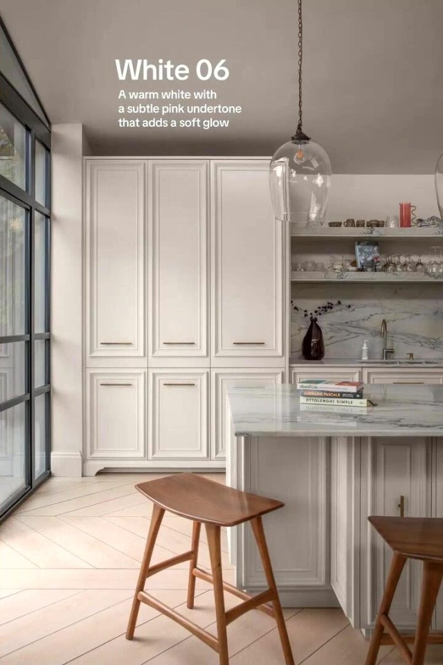 An interior shot of a kitchen featuring the paint color "White 06," described as a warm white with a subtle pink undertone.