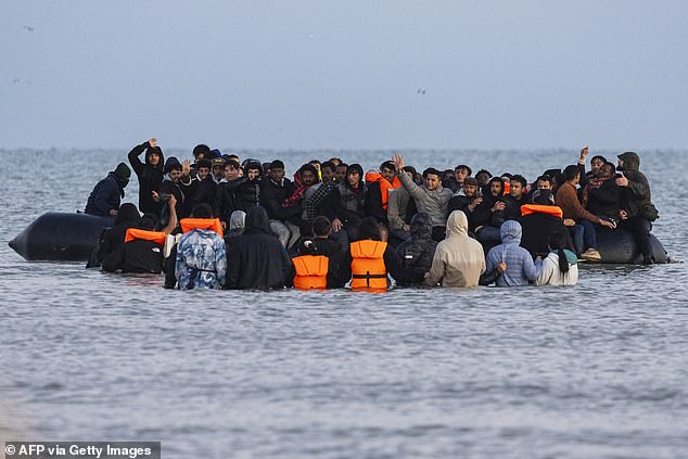 Migrants try to board a crowded smuggler's boat in an attempt to cross the English Channel off the beach of Gravelines, northern France on September 19, 2025