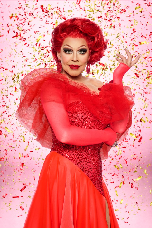 La Voix in a red gown with a red wig, red gloves, and red earrings.