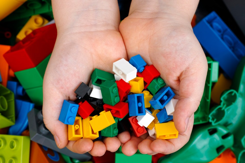 Child's hands holding colorful Lego bricks.