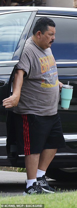He wore black athletic shorts, a gray graphic T-shirt, and black sneakers