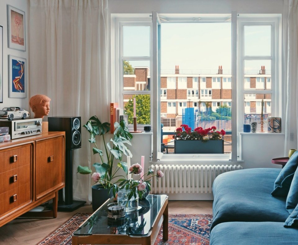 Living room with mid-century modern furniture and a view of apartment buildings.