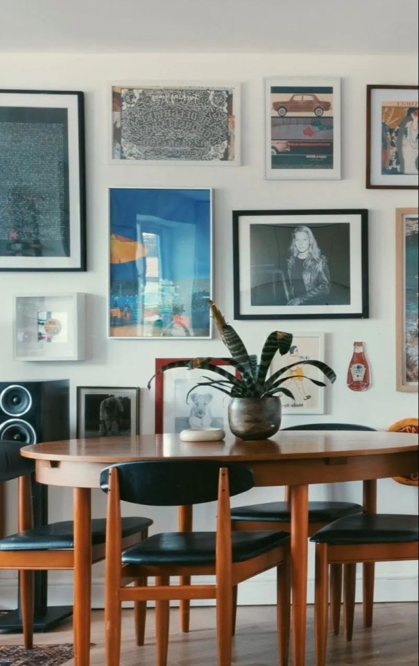 Gallery wall with framed art and a mid-century modern dining table.